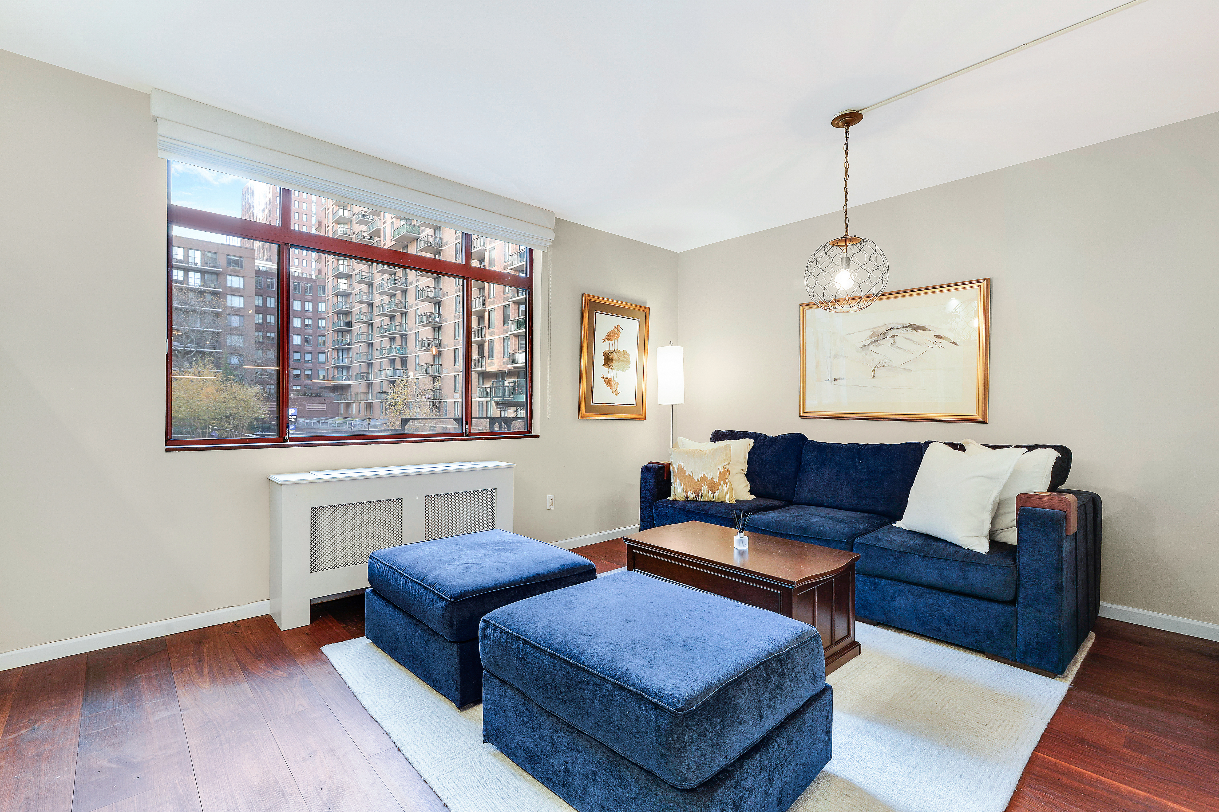 350 Albany Street, Unit 2E Manhattan, NY 10280 - Photo 1 of 8 a living room with furniture and a chandelier